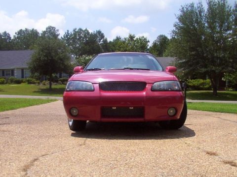2002 Nissan SE-R - Front view of a red sedan with a modified grille and aftermarket bumper details.
