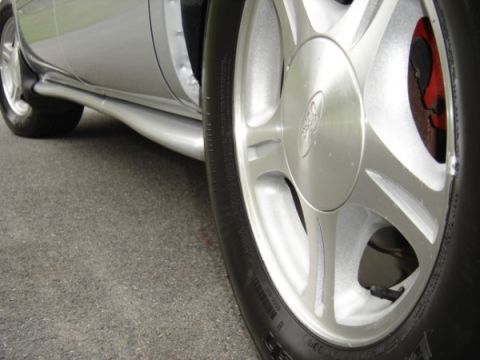 1999 Ford Taurus - Close-up of a 1999 Ford Taurus wheel and the car's silver side panel.