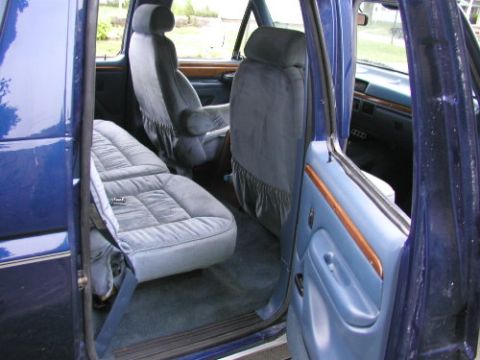1995 Ford C-350 (Centurion Conversions) - Interior view of a blue van, showing the front and rear seats, dashboard, and door panels.