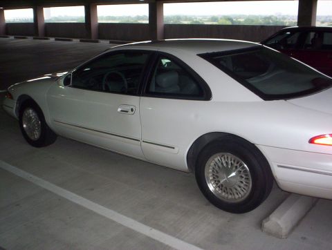 1994 Lincoln Mark VIII - Side view of a white 1994 Lincoln Mark VIII parked in a garage. A second car is visible in the background.