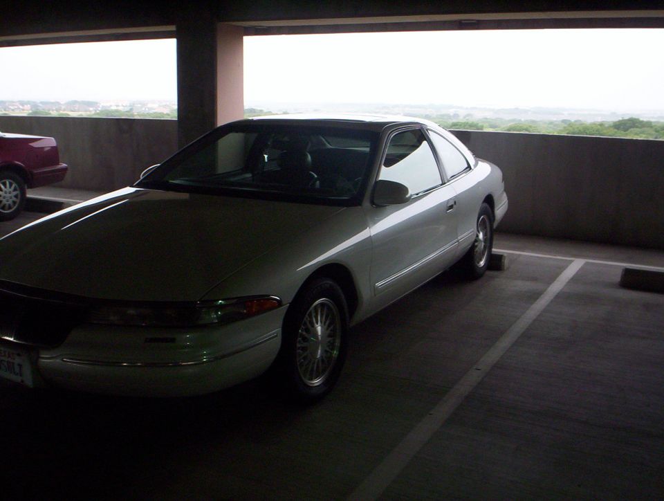 White Lincoln Mark VIII coupe, front three-quarter view on a parking garage roof