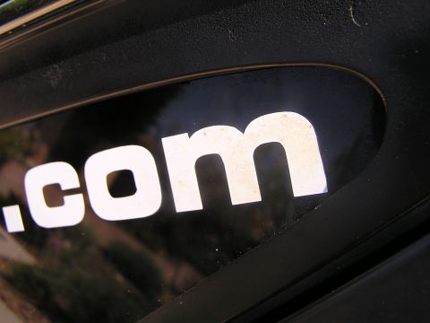 1993 Ford Taurus - Close-up of a white .com decal on a black surface.