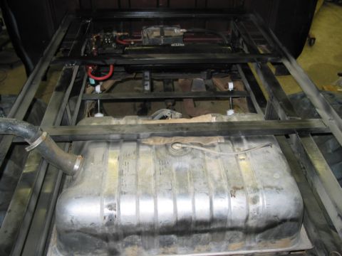 1981 Ford Bronco - The underside of a vehicle reveals a large fuel tank, exhaust system, and engine components, suggesting custom work or repair.