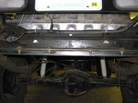 1981 Ford Bronco - Underside view of a vehicle's rear axle, leaf springs, and shocks, with a Colorado license plate above.