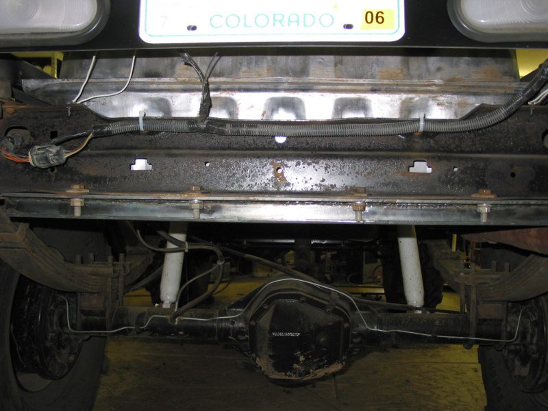 Rear underside of vehicle showing axle, leaf springs and frame with Colorado plate