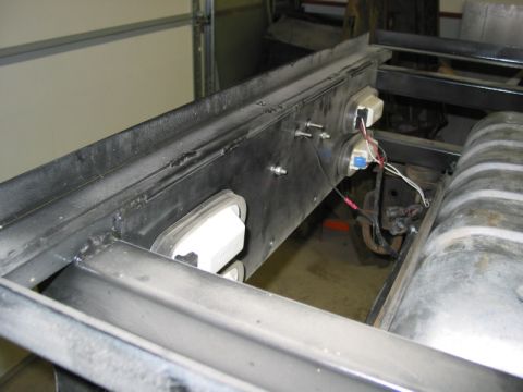 1981 Ford Bronco - The rear interior of a vehicle is shown, focusing on the wiring and fuel tank assembly.