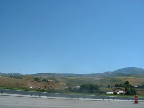 1999 Ford Crown Victoria - A wide view of a rural landscape with hills and buildings, captured on a sunny day.