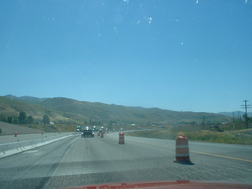 Highway construction zone with traffic and mountains in the distance
