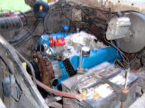 1978 Ford Bronco - Close-up view of a vehicle's engine bay, showing the engine, battery, and various hoses and wires.