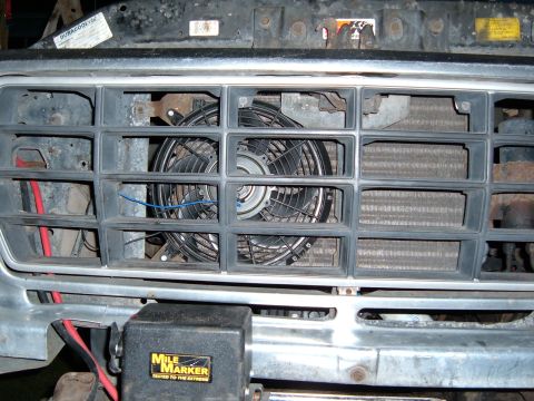 1978 Ford Bronco - Close-up of a vehicle's front grille, revealing an aftermarket electric fan and a Mile Marker winch control unit. No specific year is ident…