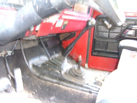 1978 Ford Bronco - Interior view of a vehicle's manual transmission setup, dual stick shifters and a red dashboard.