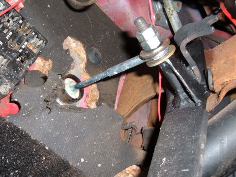 1978 Ford Bronco - Close-up view of the interior clutch linkage, showing signs of rust and wear on the carpet and floor pan.