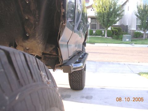 1994 Ford Bronco - Side view of a black SUV, possibly a Bronco, aftermarket rock sliders and large tires. The photo is dated August 10, 2005.