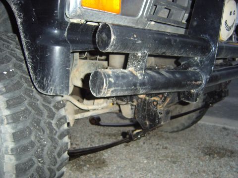 1986 Ford F-150 - Close-up of a modified Ford F-150's front end, showing heavy-duty bumper and suspension components.