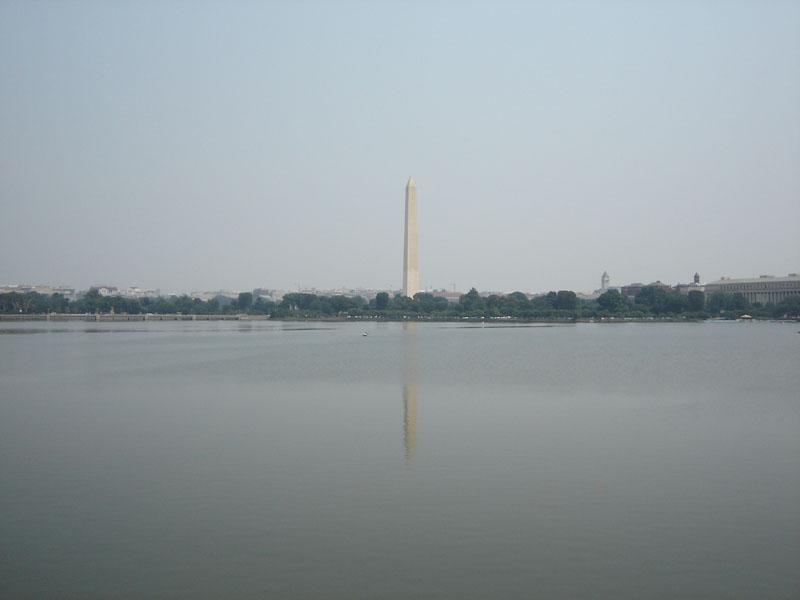 Washington Monument reflected in water with city skyline