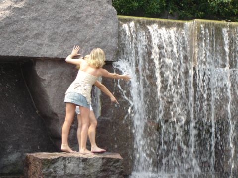 1986 Ford Bronco - Two women enjoy the refreshing spray of a waterfall while standing on large rocks.