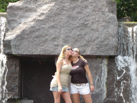 1986 Ford Bronco - Two women share a kiss in front of a large rock formation with water cascading down its sides.