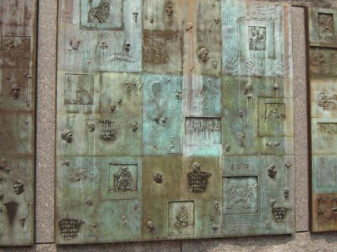 1986 Ford Bronco - This is a close-up of a large bronze relief sculpture many individual panels with varied artistic depictions.