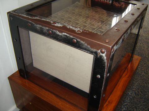 1986 Ford Bronco - A coffee table displays a collection of US currency under a glass top, framed by riveted metal.