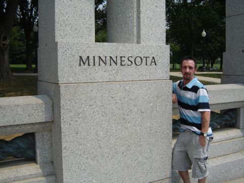 1986 Ford Bronco - Man poses by a stone monument that has 'MINNESOTA' carved into it.
