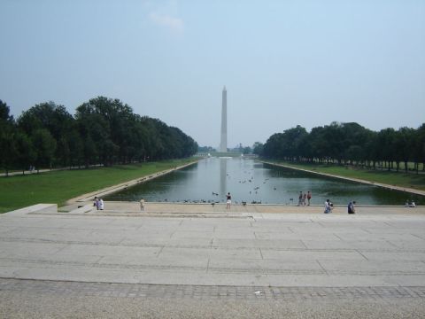 1986 Ford Bronco - The Washington Monument stands tall over the reflecting pool, surrounded by trees and visitors.