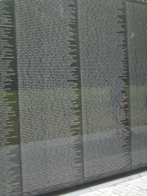 Vietnam Veterans Memorial wall with names etched into black granite panels