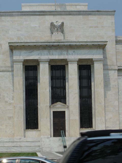 1986 Ford Bronco - The Federal Reserve building facade is seen with a partial view of a car in the foreground.