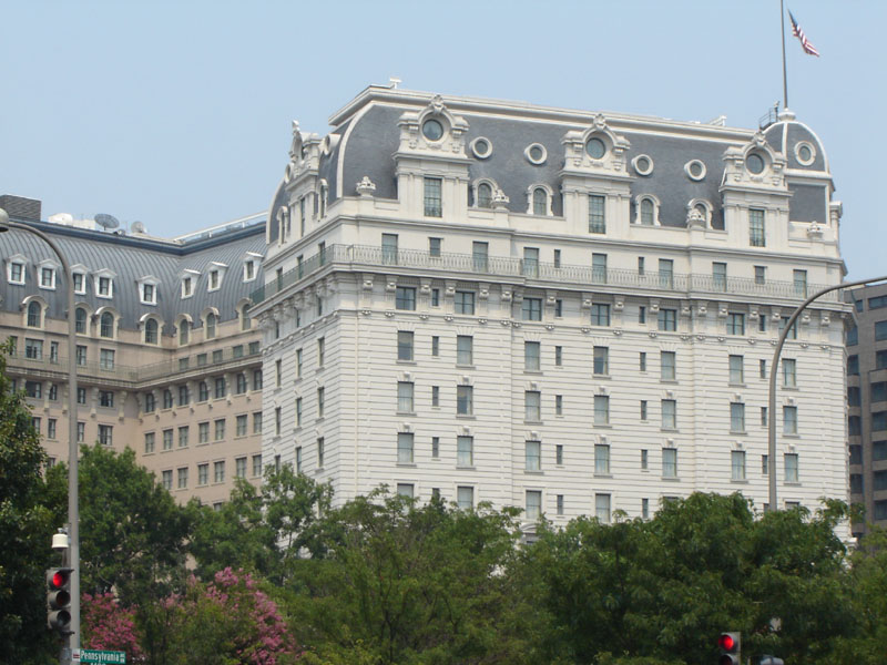 Large white building with ornate architecture and a flag on top