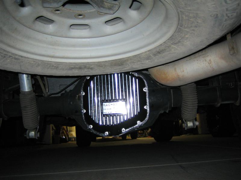 Finned aluminum differential cover on a truck rear axle viewed from underneath