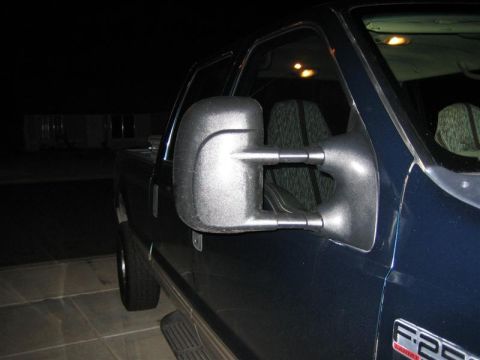 1999 Ford F-250 - The side mirror and door panel of a pickup truck are visible in this nighttime photo.