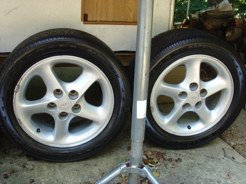 1993 Ford Probe - Two silver alloy wheels with tires are shown, likely for a car. The registry claims they are from a 1993 Ford Probe, but this cannot be con…
