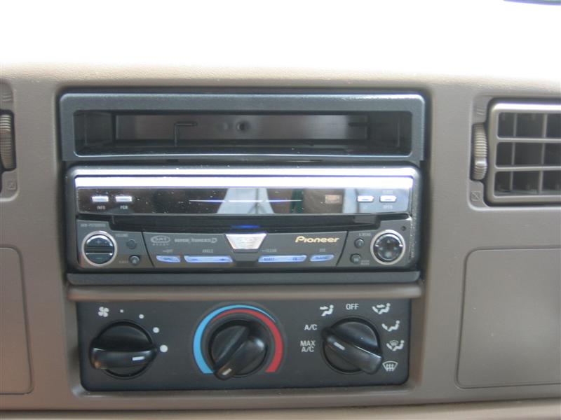 Car interior showing a Pioneer stereo above climate controls with knobs and vents