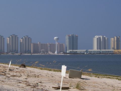 1995 Ford Bronco - A view of a coastline with several tall buildings and a water tower under a clear blue sky.