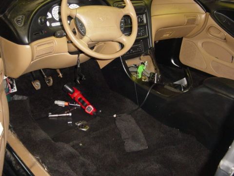 1995 Ford Mustang - Interior view of a 1995 Ford Mustang, with tools laid out on the carpeted floor.