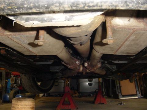 1995 Ford Mustang - The vehicle's undercarriage shows a dual exhaust system with visible mufflers and pipes.