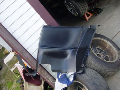 1995 Ford Mustang - A black car panel is shown in a cluttered garage setting with multiple tires visible.