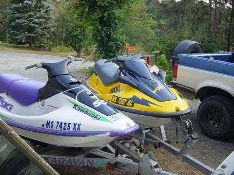 1995 Ford Mustang - Two jet skis are parked on a trailer, with a pickup truck visible in the background.