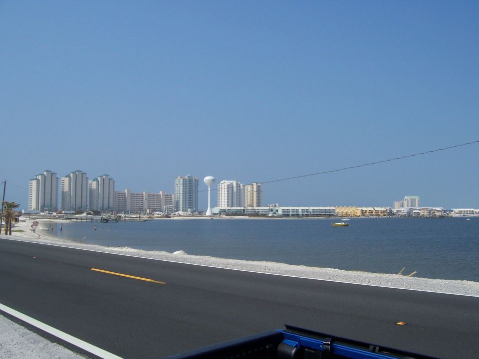 View of a coastal city skyline across the water from a road