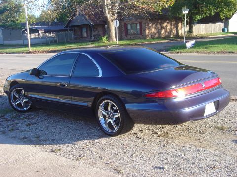 1994 Lincoln Mark VIII - This 1994 Lincoln Mark VIII is shown in a rear three-quarter view, highlighting its distinctive body style and chrome wheels.