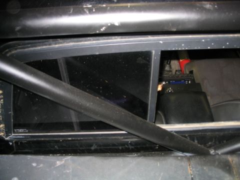 1986 Ford F-150 - Close-up view of a vehicle's interior roll cage and rear window area, showing some installed equipment.