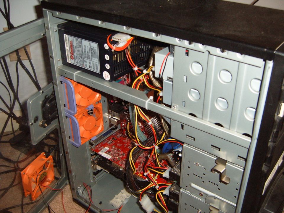 Computer tower interior with power supply, fans, and wiring visible