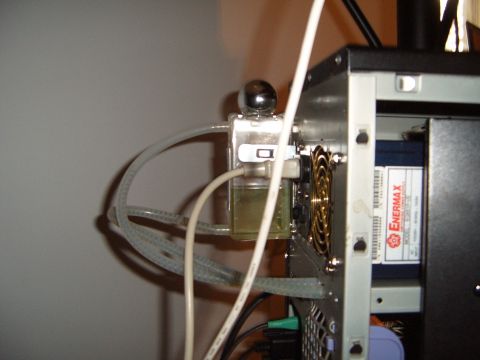 1988 Ford Bronco - Close-up of a computer's internal water cooling system reservoir, showing tubing and yellow fluid.