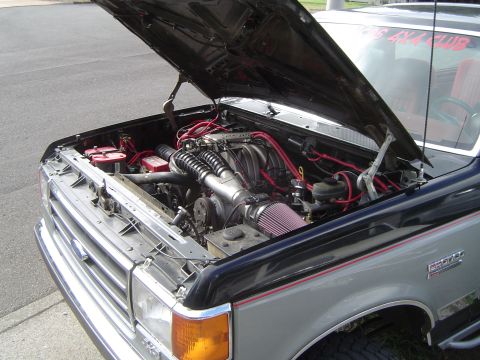 1989 Ford Bronco - The engine bay of a Ford Bronco, a modified engine with custom wiring and air intake.