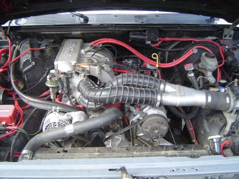 1989 Ford Bronco - The engine bay of a vehicle is shown with various components and wiring.