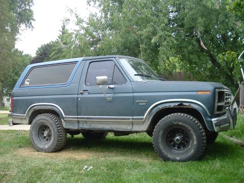 1982 Ford Bronco - Side view of a blue 1982 Ford Bronco, showing its off-road tires and classic body style.