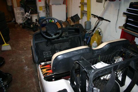 1989 Ford Bronco - This golf cart's interior features a flame-patterned seat and a standard steering wheel and pedal setup.