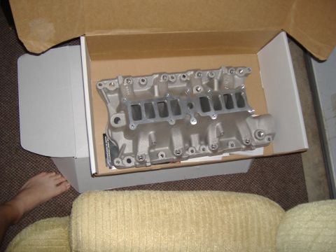 1996 Ford Bronco - An Edelbrock intake manifold is shown inside its shipping box, placed on a carpeted floor near a couch.