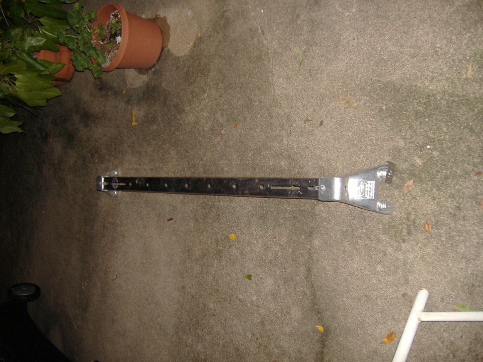 Metal bracket with holes and wrench-like end, Supermotors.net logo visible
