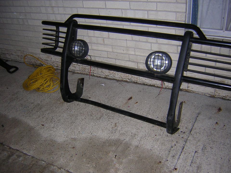 Black brush guard with two round lights and a coiled yellow cord