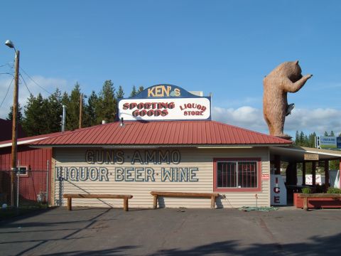 1989 Ford Bronco - A roadside store features a large bear statue and prominent signage for sporting goods, liquor, beer, and wine.